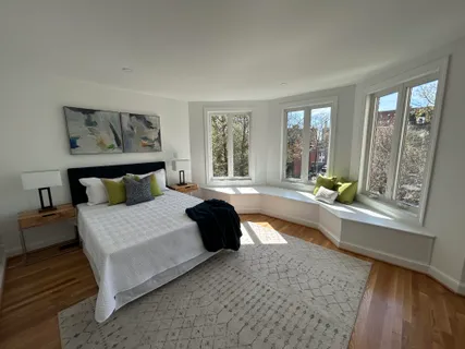 a spacious bedroom with a bed and a large window