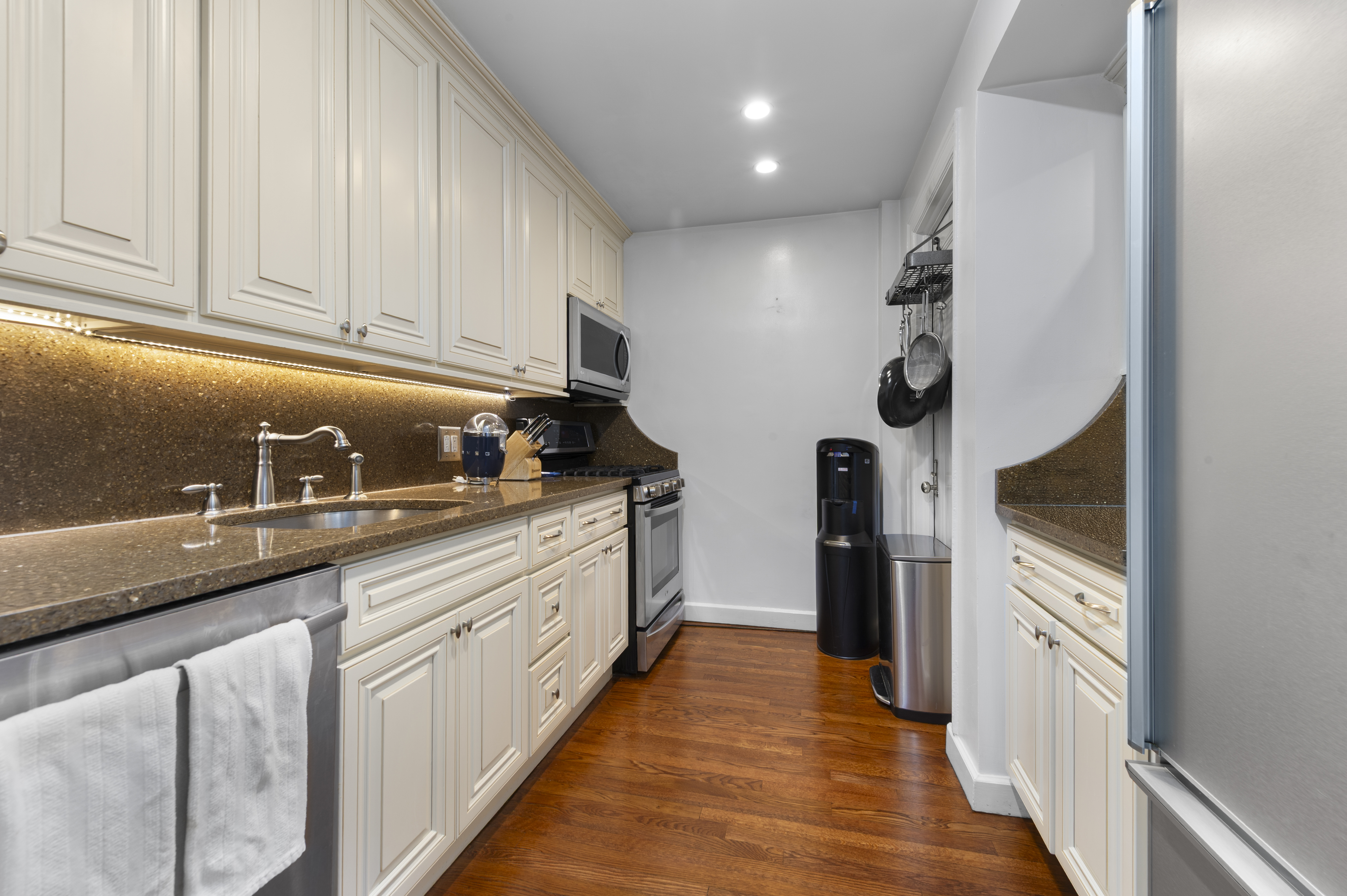 1 West 67th Street, Unit 2M Manhattan, NY 10023 - Photo 4 of 15 a kitchen with stainless steel appliances granite countertop a refrigerator and a sink