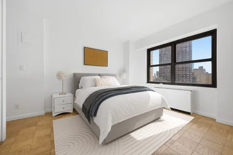 a bedroom with a bed and a large window