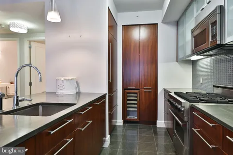 a kitchen with granite countertop a sink stainless steel appliances and cabinets