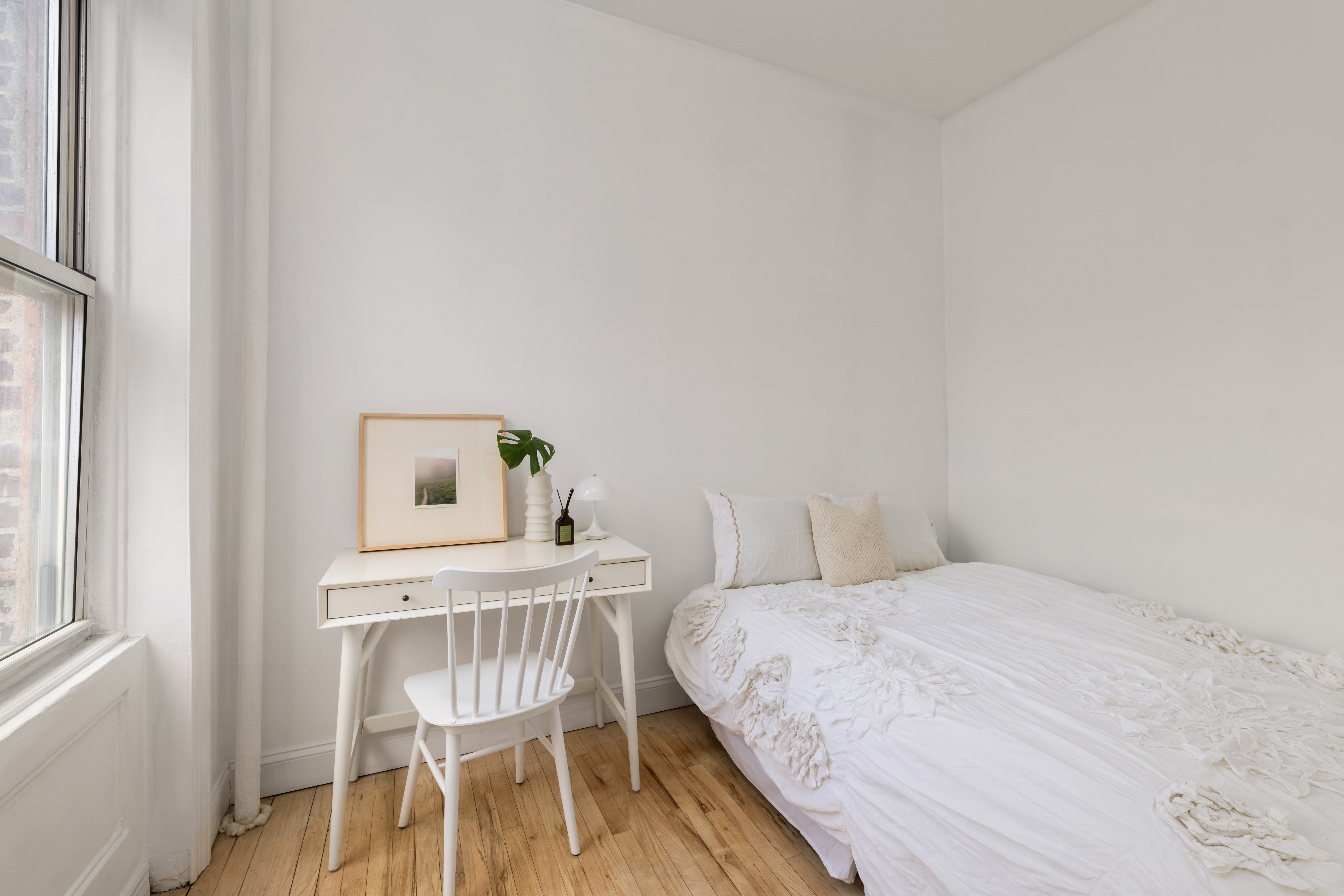 345 West 4th Street, Unit 8 Manhattan, NY 10014 - Photo 4 of 7 a bedroom with a bed and a chair