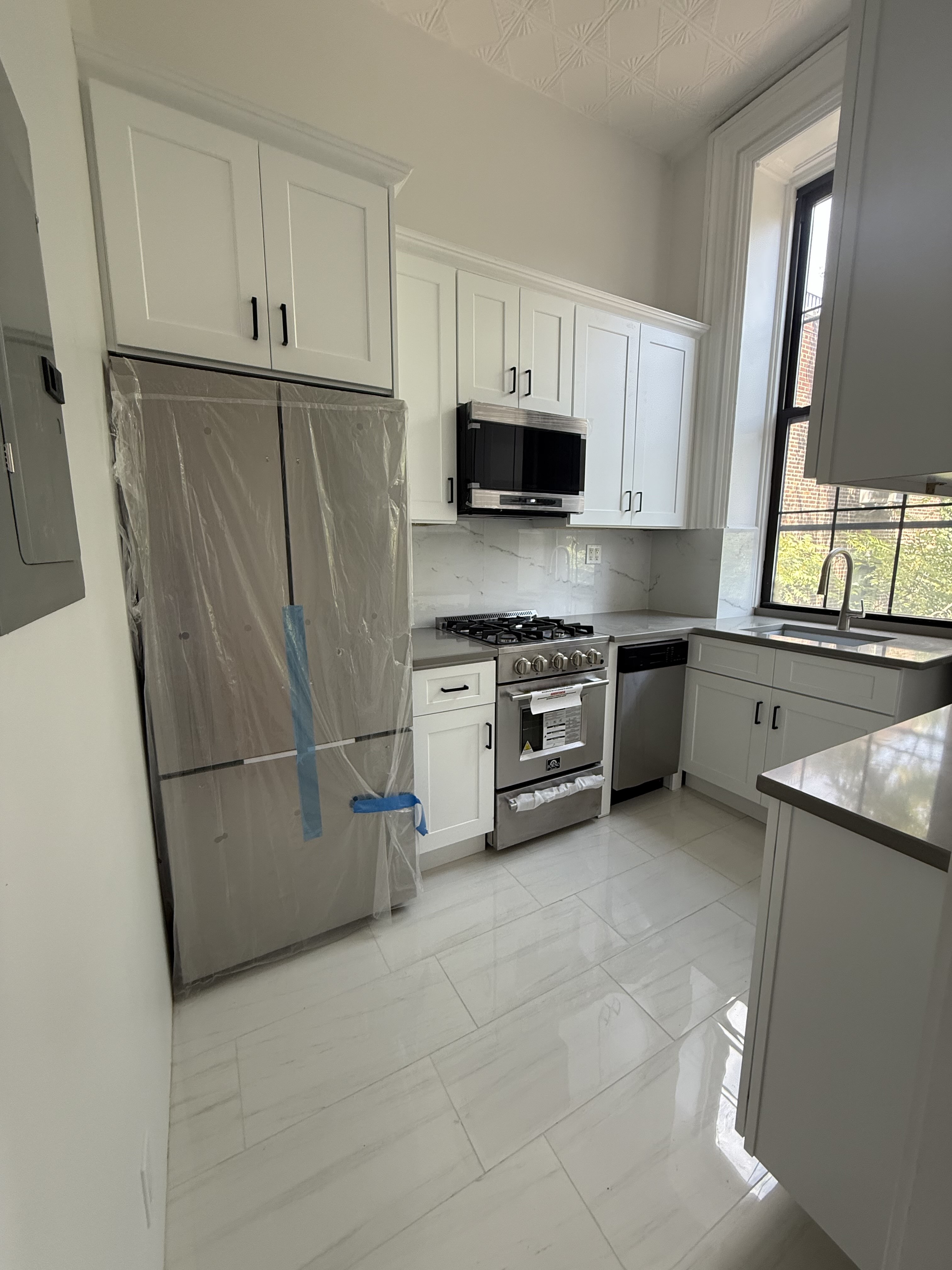 a kitchen with stainless steel appliances a refrigerator sink and microwave