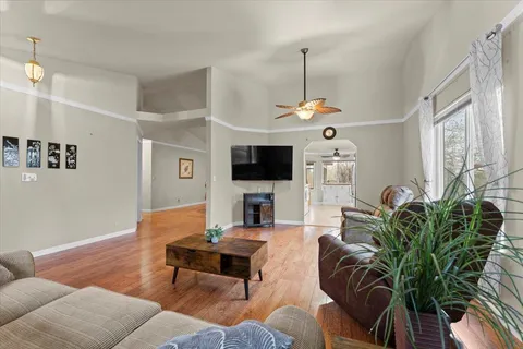 a living room with furniture a flat screen tv and a chandelier