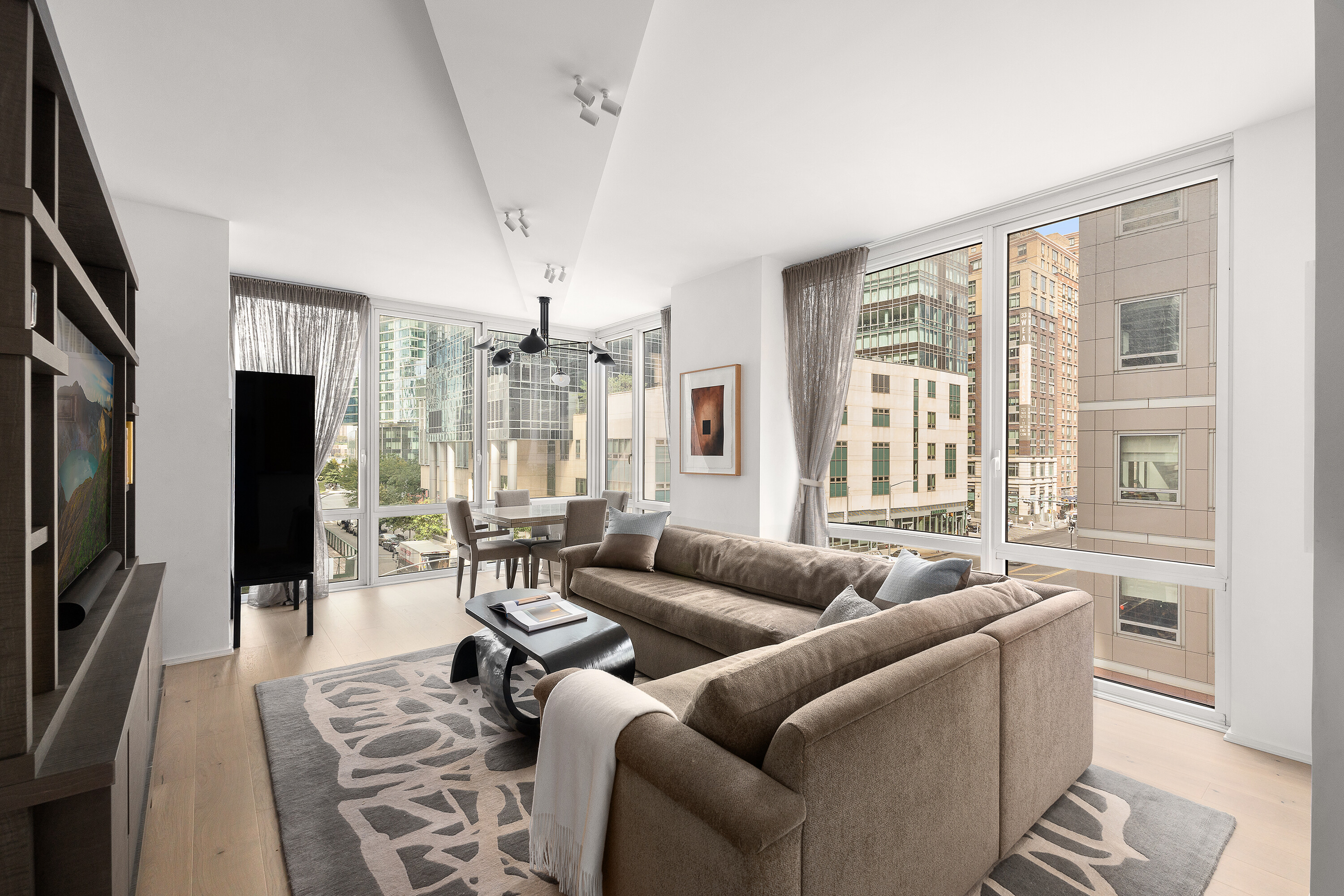 a living room with furniture a large window and a flat screen tv