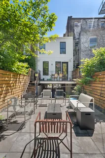 a view of a patio with couches table and chairs and potted plants