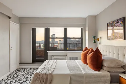 a bedroom with a bed and a large window