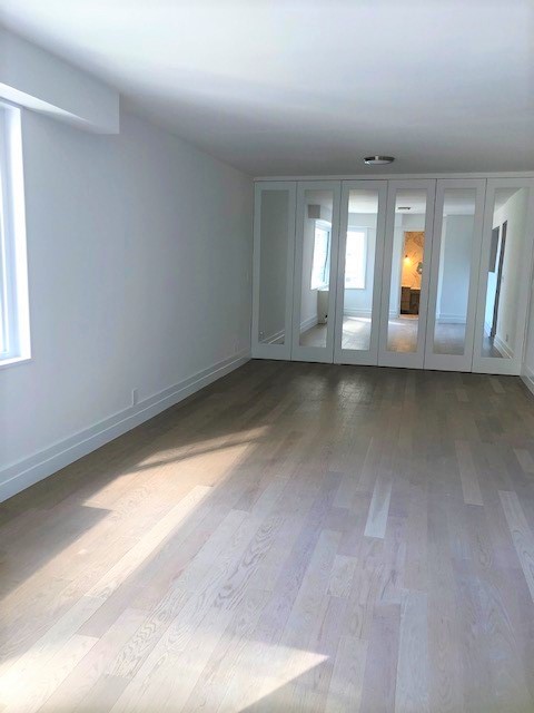 400 East 54th Street, Unit 19H Manhattan, NY 10022 - Photo 5 of 15 a view of empty room with wooden floor and fan