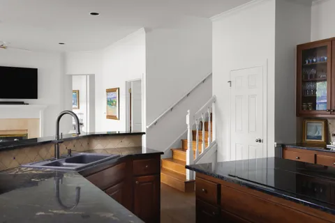 a kitchen with granite countertop a sink a stove and cabinets
