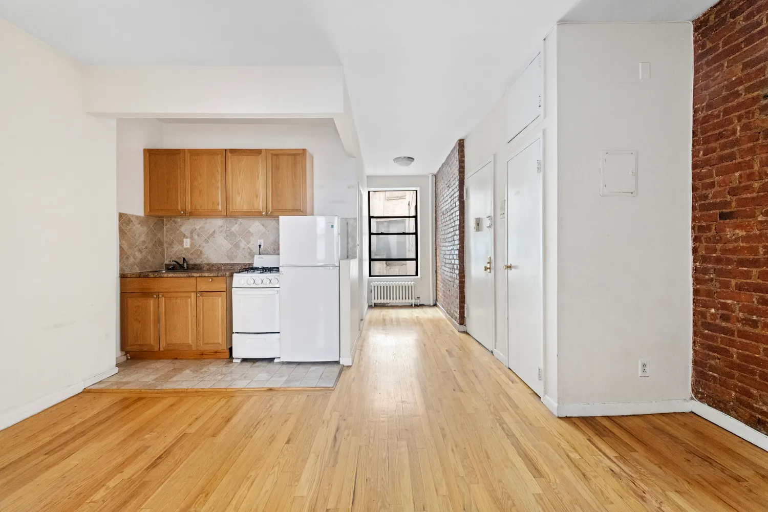 a view of a kitchen with wooden floor and a refrigerator