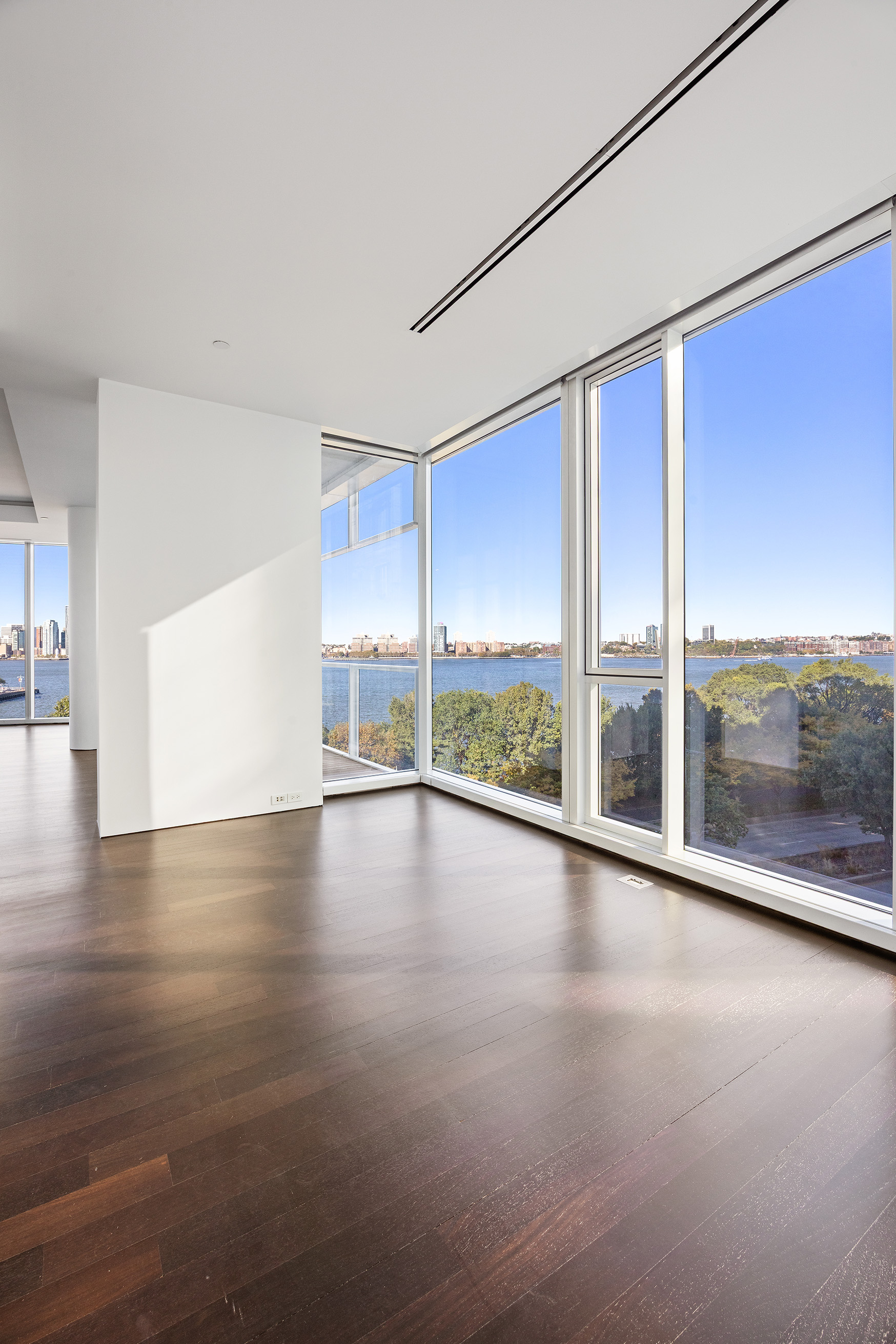 165 Charles Street, Unit 14 Manhattan, NY 10014 - Photo 9 of 18 a view of empty room with wooden floor and floor to ceiling window