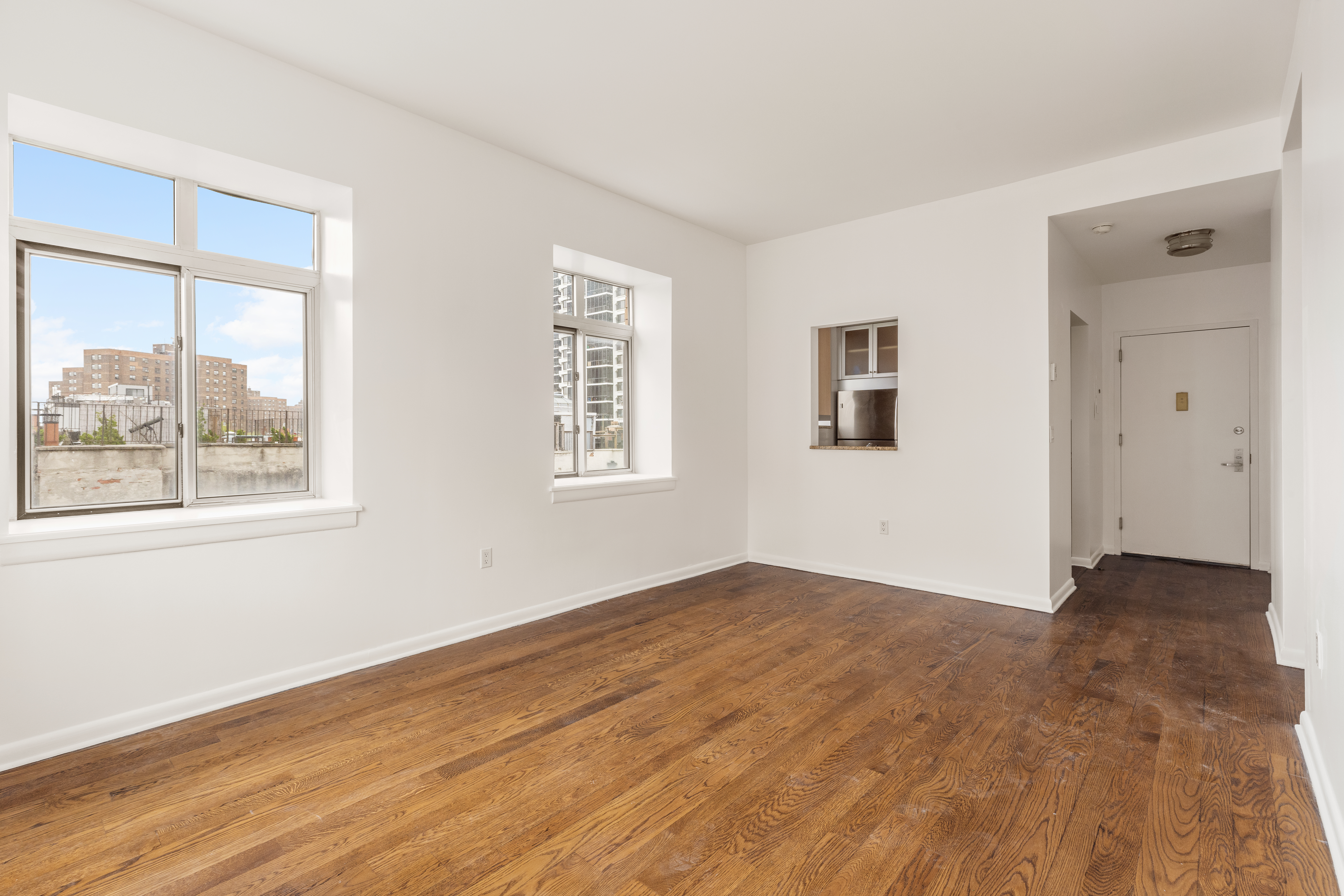 2279 3rd Avenue, Unit 6B Manhattan, NY 10035 - Photo 2 of 10 a view of an empty room with wooden floor and a window