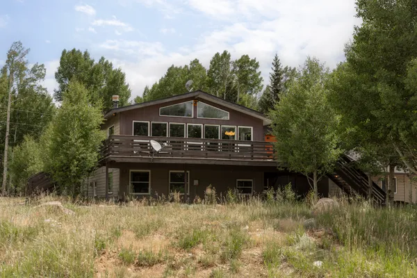 a view of house with outdoor space and trees