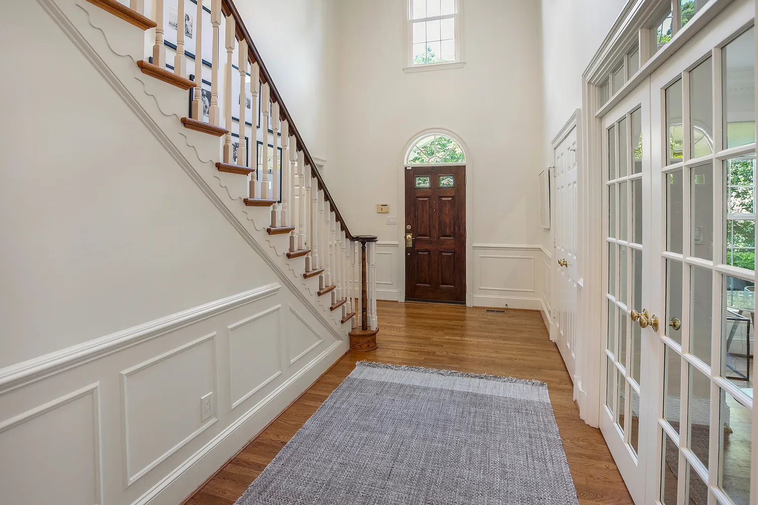 a view of staircase with lots of frames on wall and a window