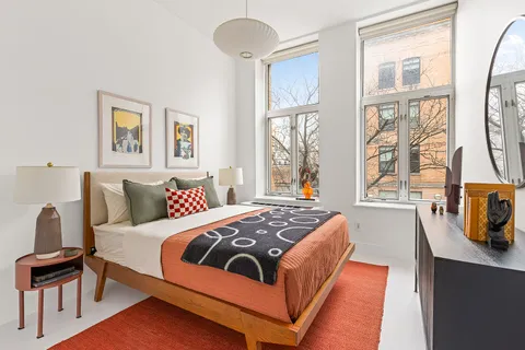 a bedroom with a bed and wooden floor