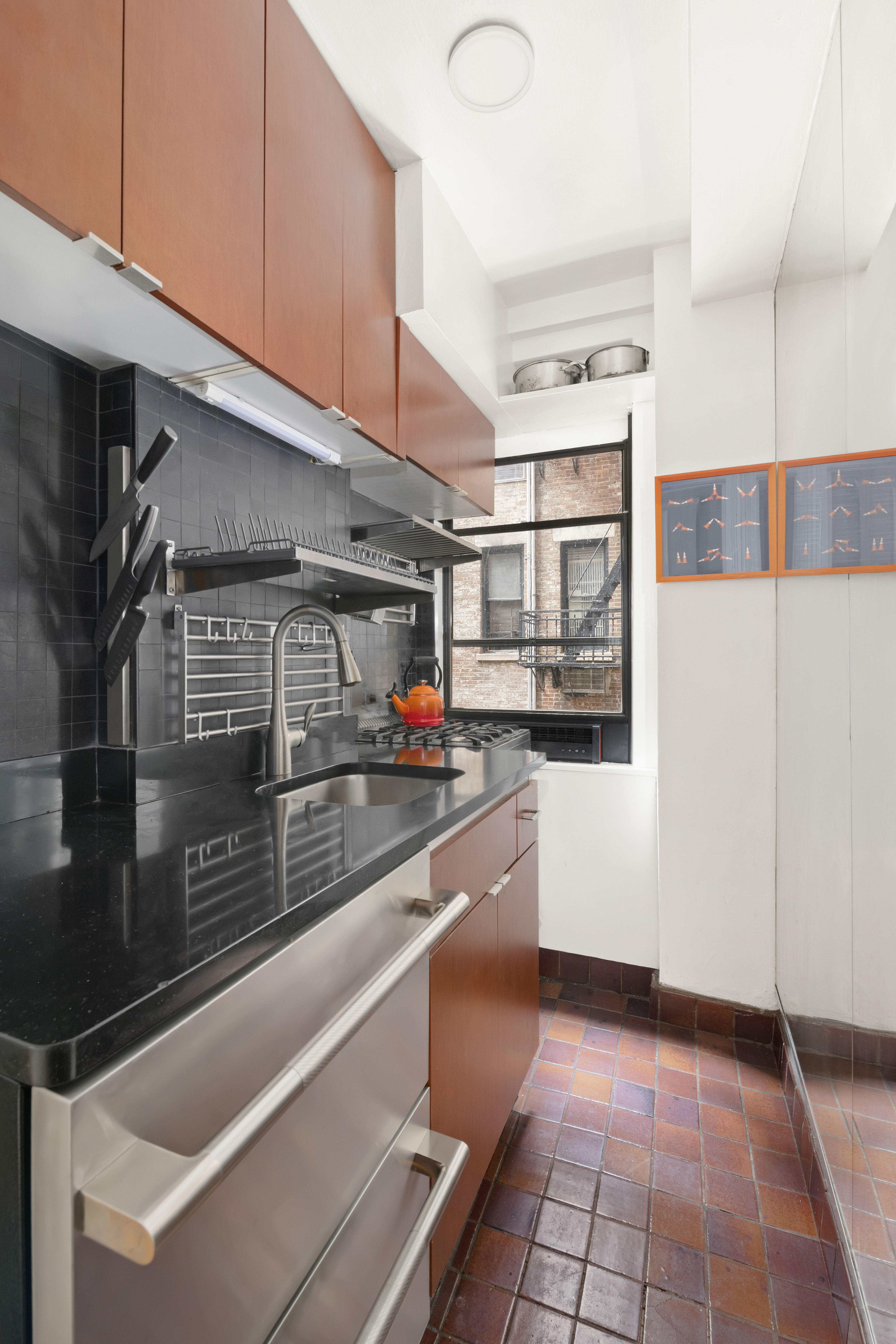 45 5th Avenue, Unit 9D Manhattan, NY 10003 - Photo 3 of 7 a kitchen with stainless steel appliances kitchen island granite countertop a sink and cabinets