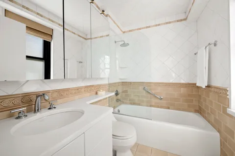 a bathroom with a sink a toilet a mirror and bathtub