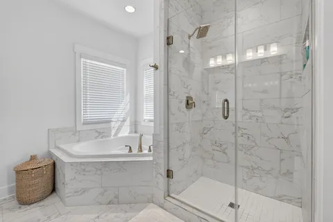 a bathroom with a tub shower and window