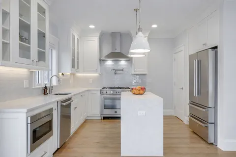 a kitchen with stainless steel appliances granite countertop a sink a stove and a refrigerator