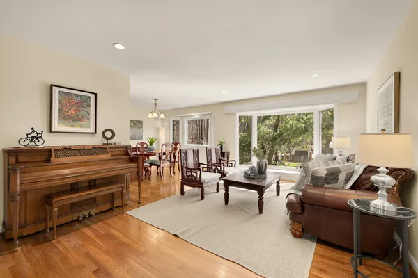 a living room with furniture kitchen view and a wooden floor