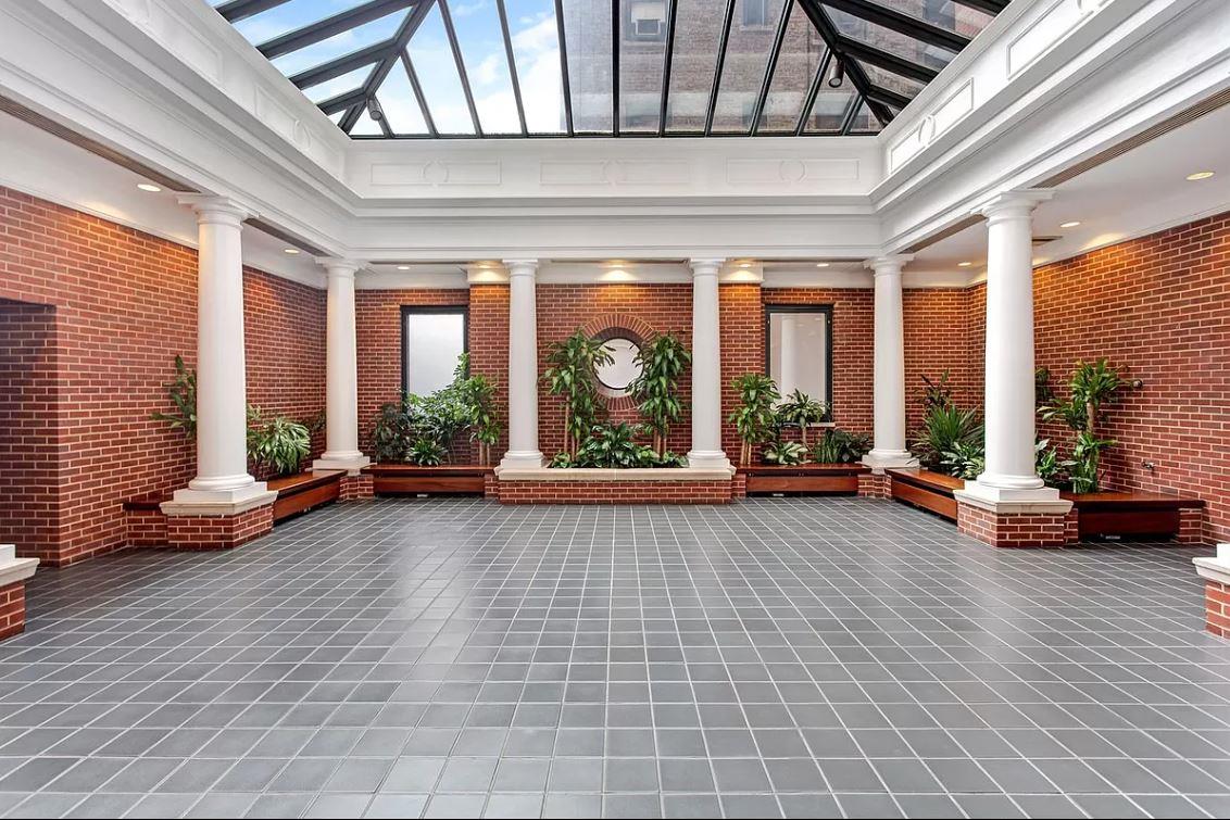 188 East 70th Street, Unit 8E Manhattan, NY 10021 - Photo 8 of 10 a living room with furniture and floor to ceiling windows