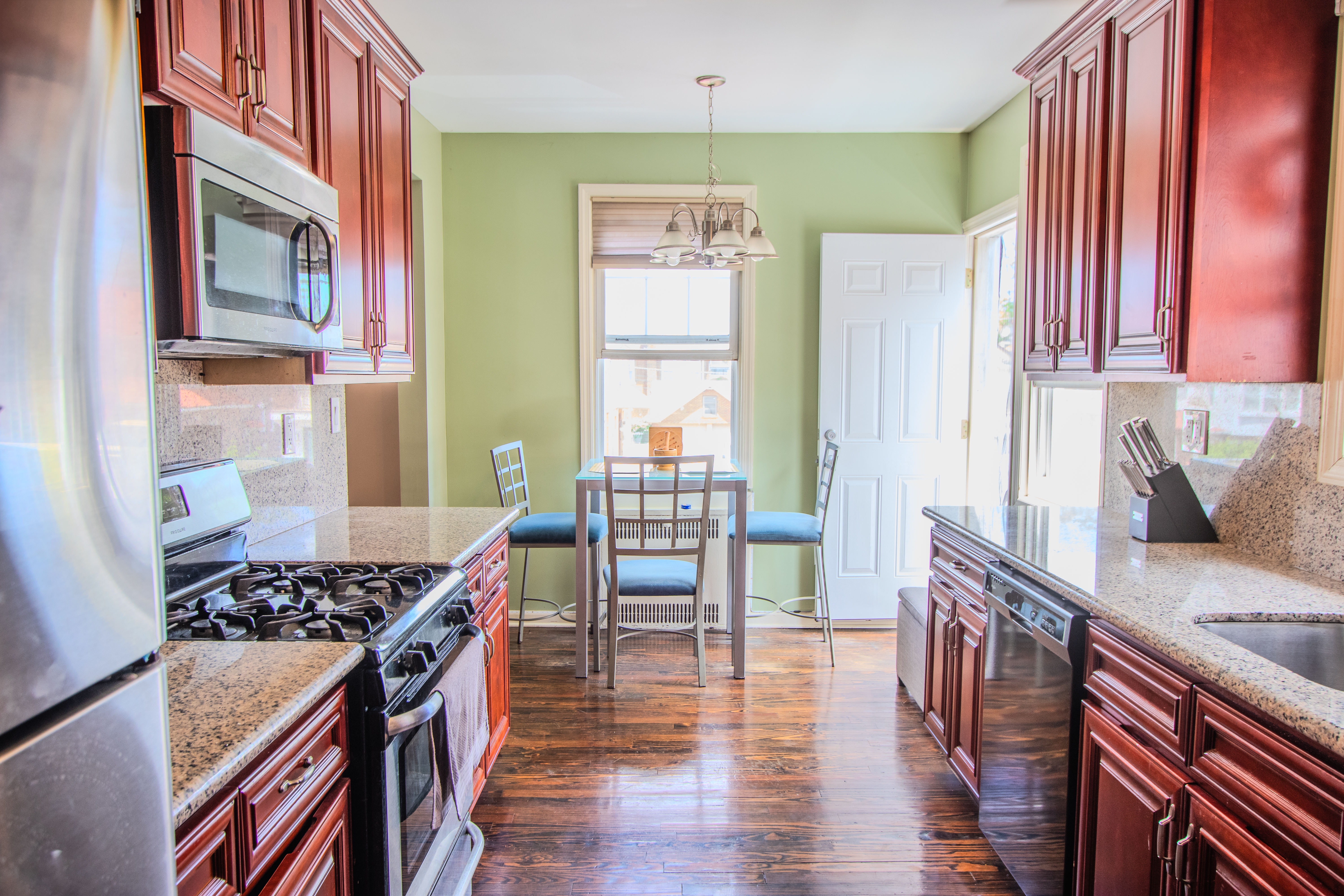 238 West End Avenue Brooklyn, NY 11235 - Photo 7 of 13 a kitchen with stainless steel appliances granite countertop a stove a sink dishwasher and wooden cabinets with wooden floor