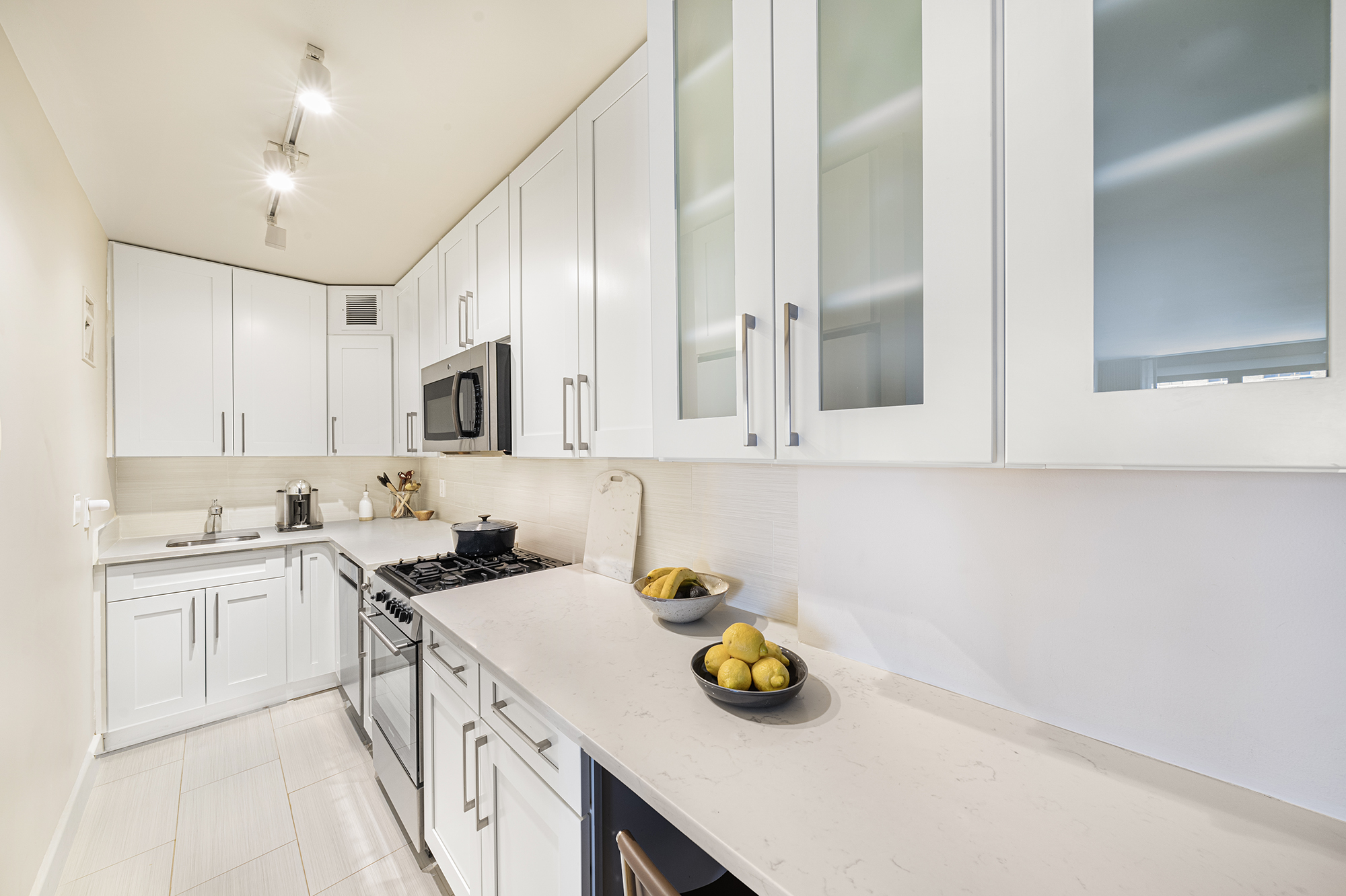 301 East 62nd Street, Unit 7K Manhattan, NY 10065 - Photo 6 of 14 a kitchen with a sink a stove and cabinets