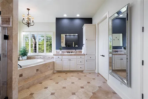 a bathroom with a sink a large mirror and a bathtub with shower