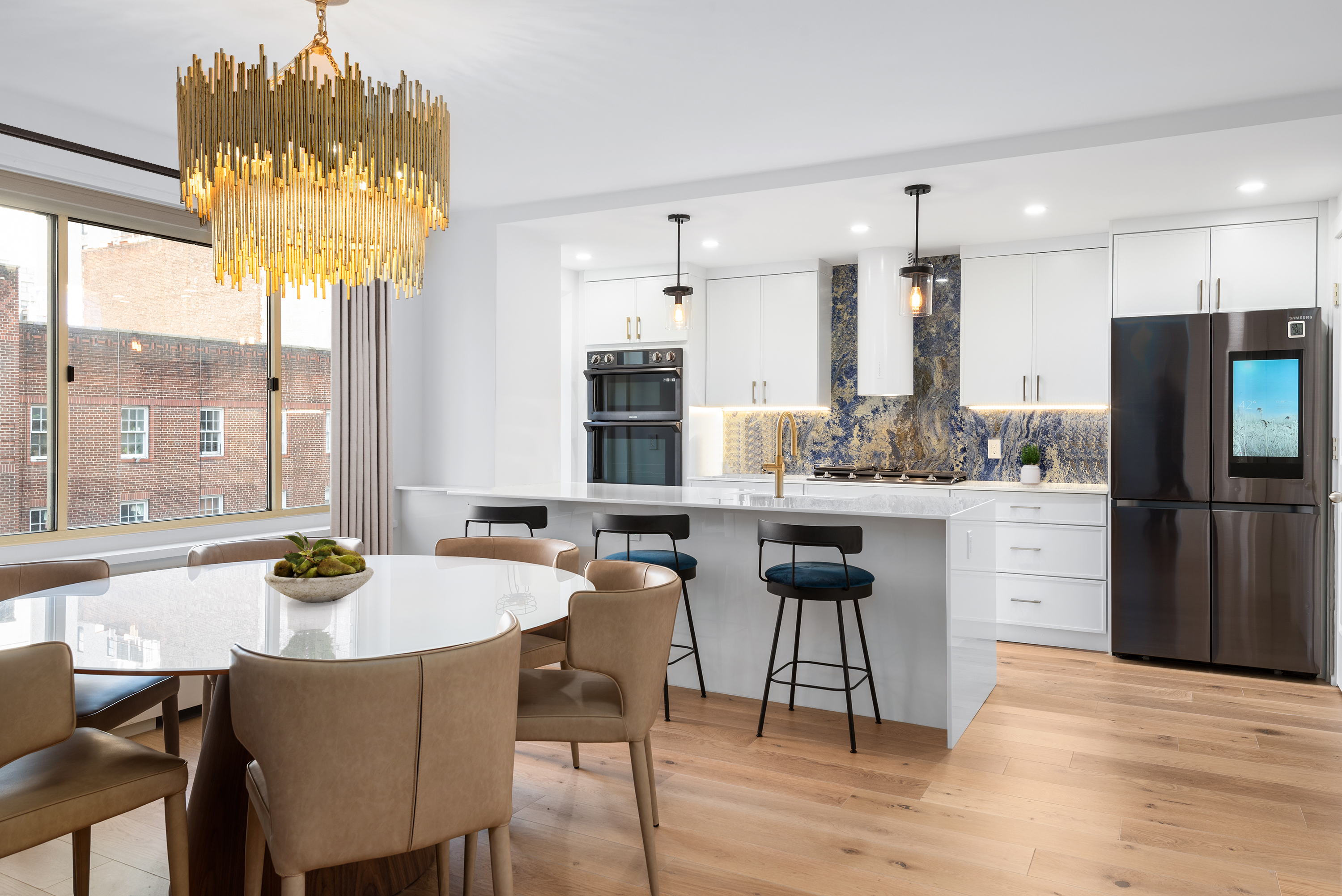 30 East 65th Street, Unit 6B Manhattan, NY 10065 - Photo 3 of 14 a kitchen with a table chairs stove and kitchen island