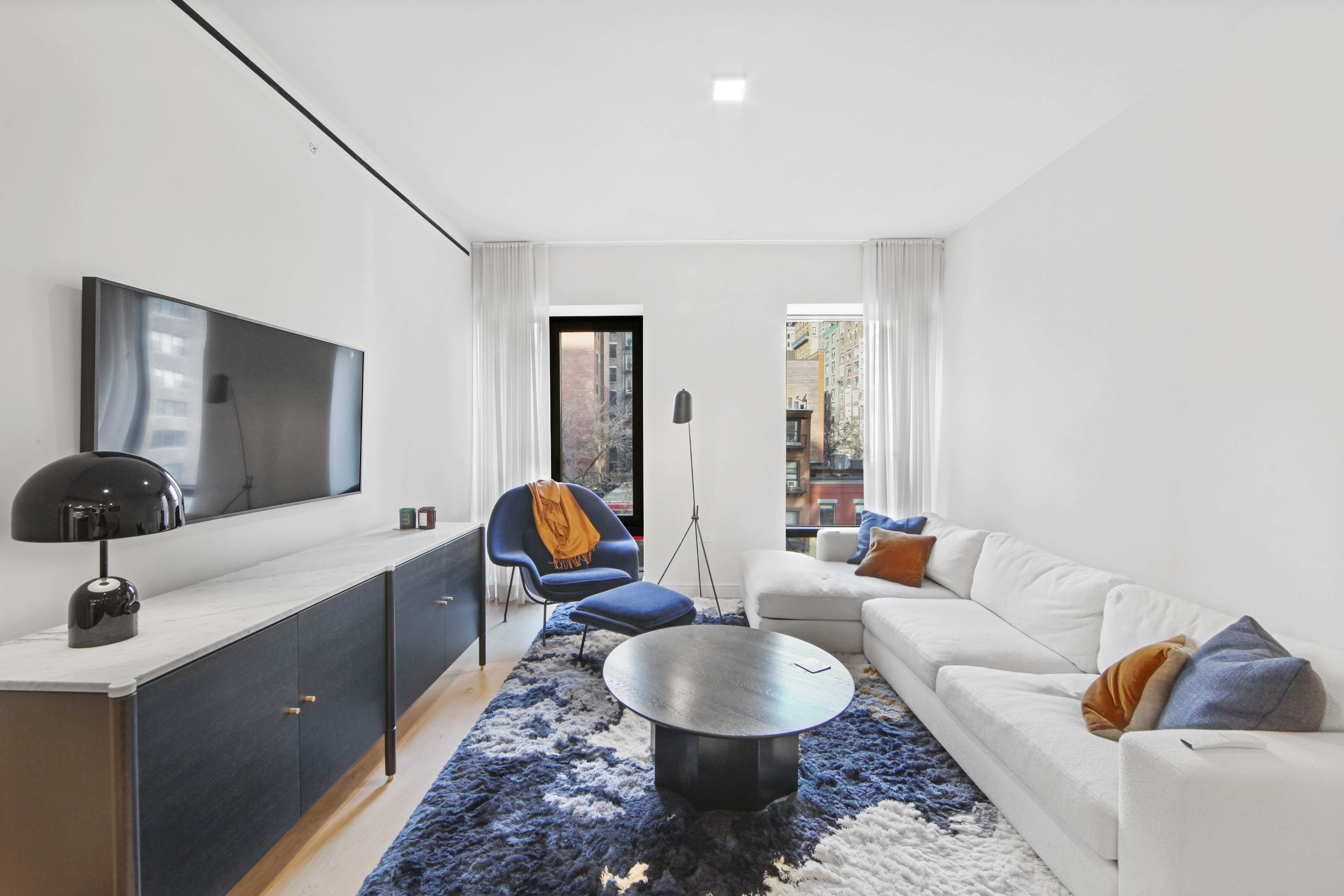 200 East 21st Street, Unit 4B Manhattan, NY 10010 - Photo 3 of 15 a living room with furniture and a flat screen tv