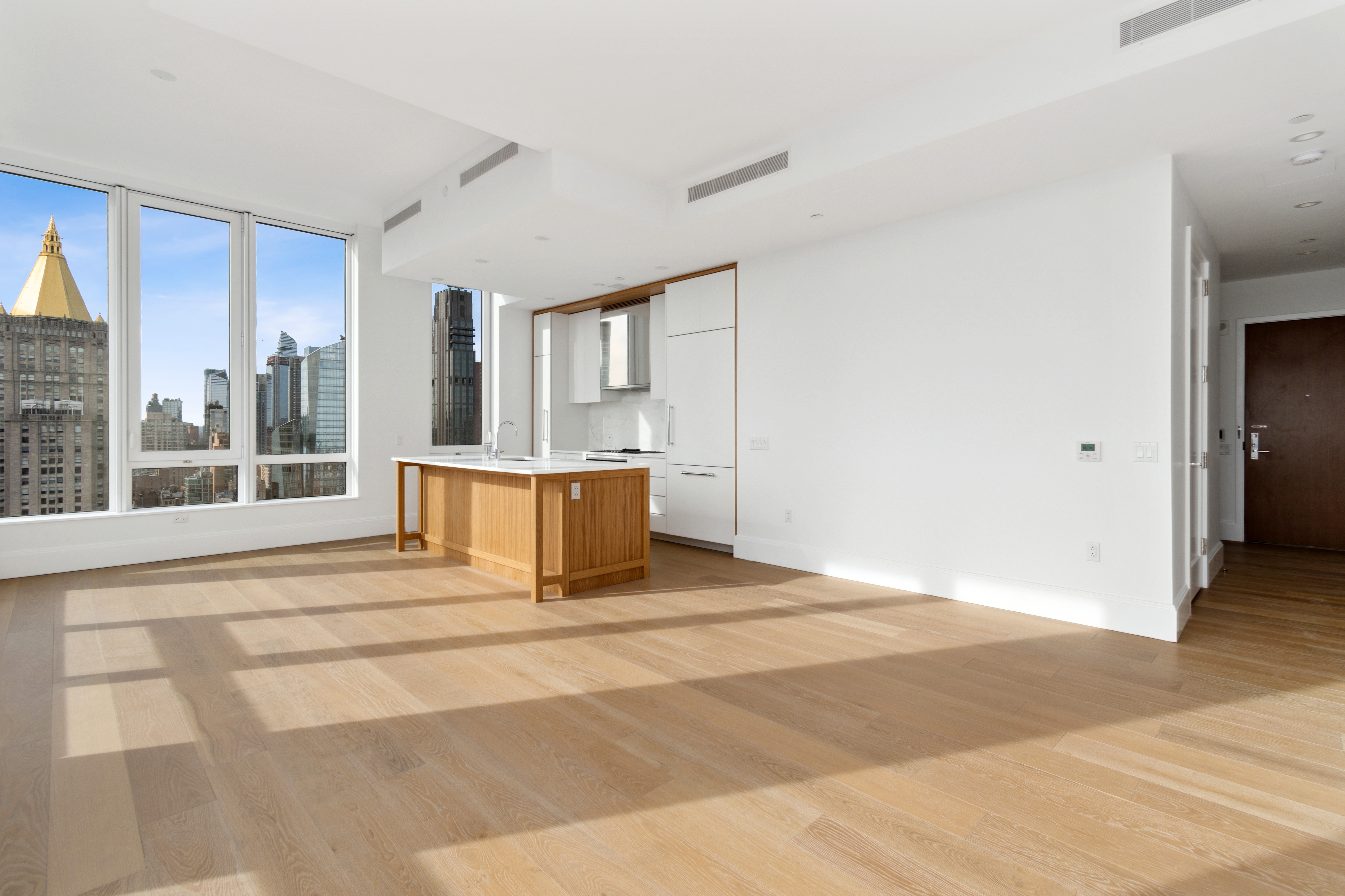 368 3rd Avenue, Unit 32B Manhattan, NY 10016 - Photo 4 of 19 a view of an empty room with wooden floor and a fireplace