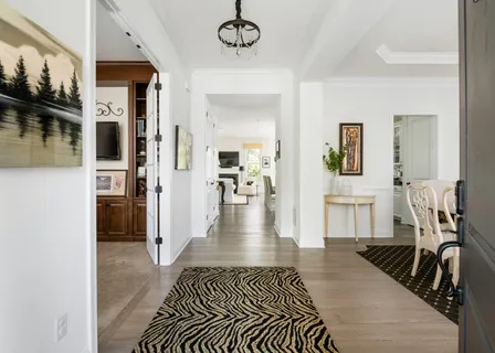 a view of a hallway with wooden floor and a livingroom view