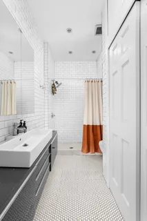a bathroom with a sink a mirror a vanity and a shower