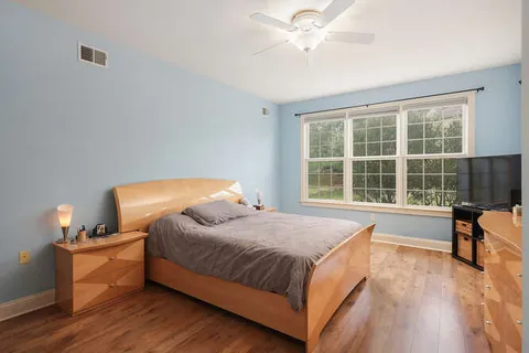 a bedroom with a bed and wooden floor
