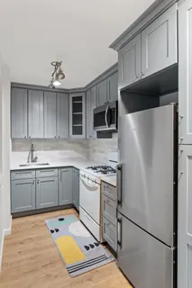 a kitchen with stainless steel appliances granite countertop a refrigerator sink and stove