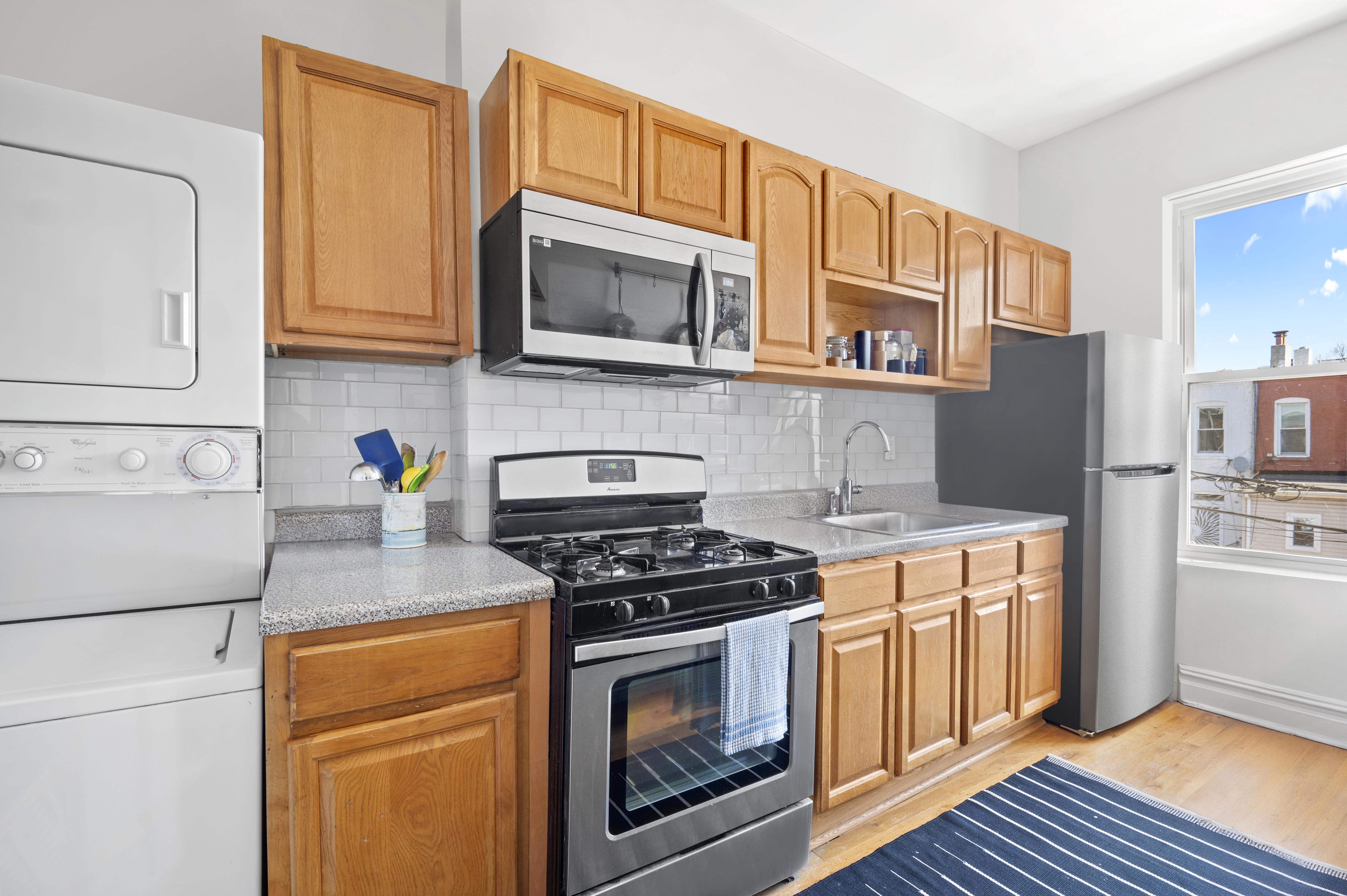 185 East 31st Street Brooklyn, NY 11226 - Photo 17 of 23 a kitchen with stainless steel appliances granite countertop a stove a microwave and a refrigerator