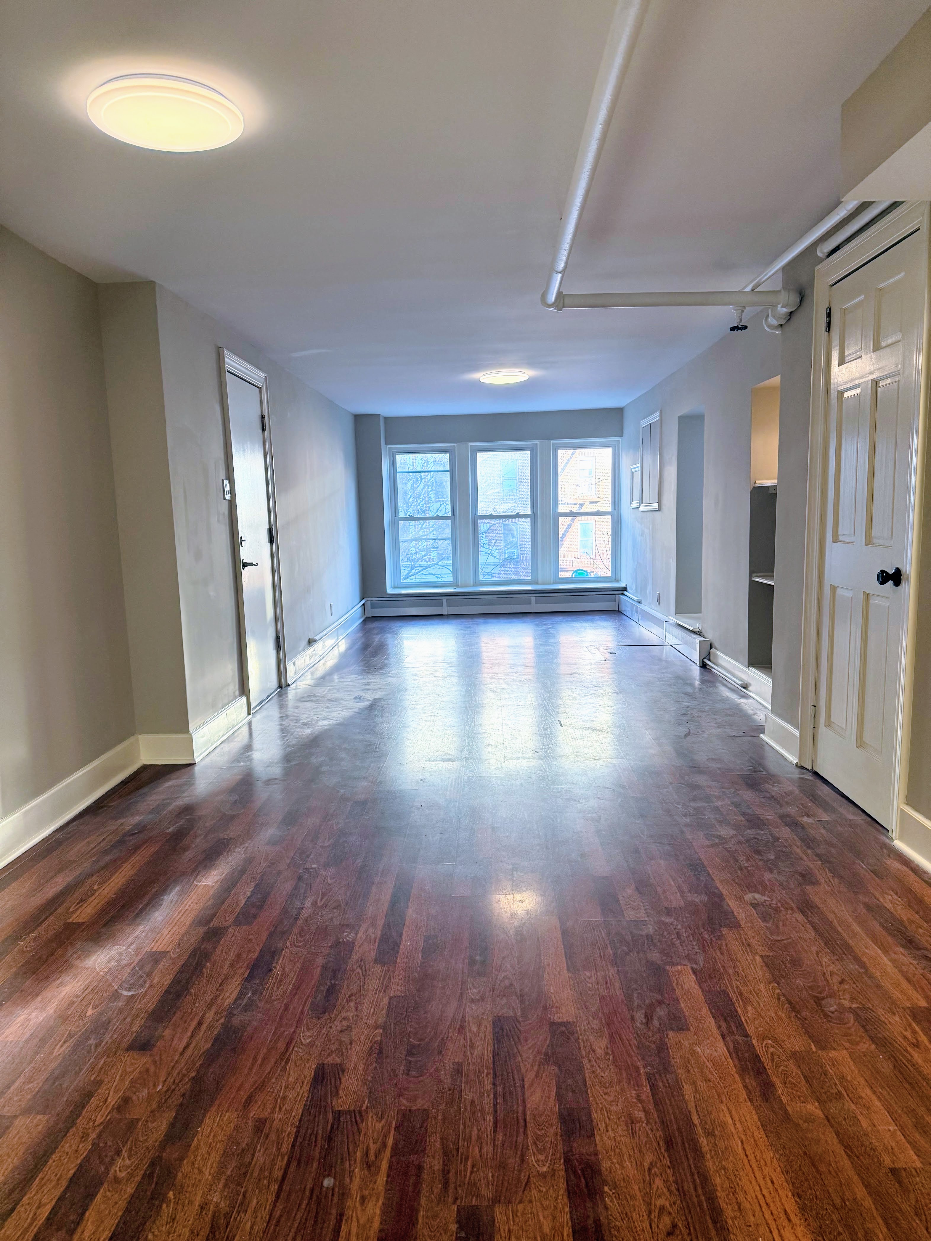wooden floor in an empty room with a window
