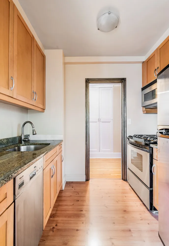 a kitchen with granite countertop a sink stainless steel appliances and cabinets