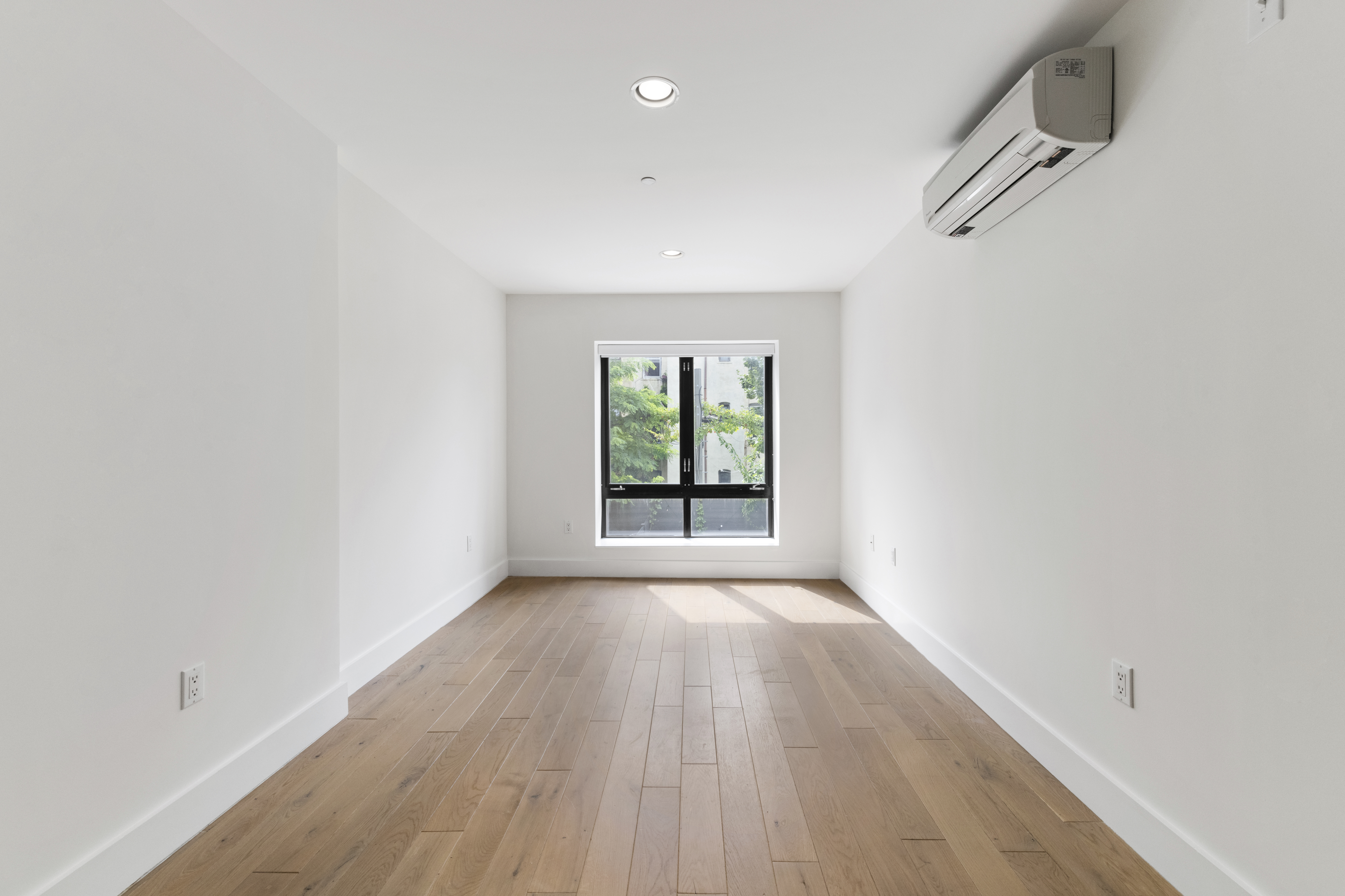 1168 Greene Avenue, Unit 2B Brooklyn, NY 11221 - Photo 7 of 11 a view of an empty room with wooden floor and a window