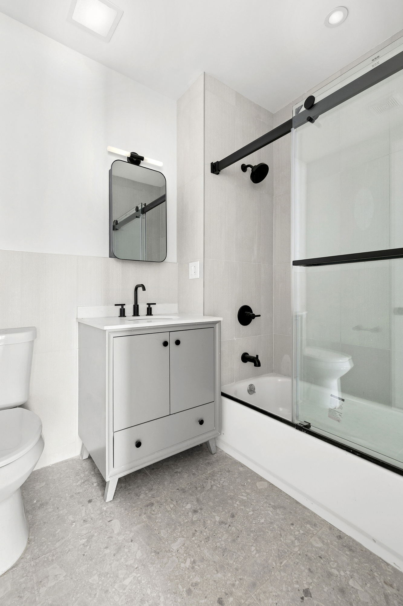 647 Dekalb Avenue, Unit 3A Brooklyn, NY 11216 - Photo 5 of 7 a bathroom with a double vanity sink toilet and shower