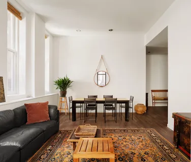 a living room with furniture a dining table and a potted plant