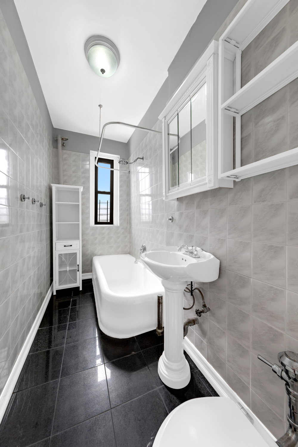 37-20 83rd Street, Unit 6J Queens, NY 11372 - Photo 8 of 14 a bathroom with a sink toilet and a mirror