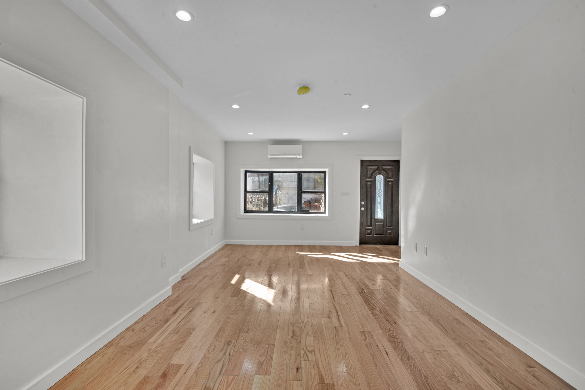 31 Roosevelt Place, Unit 1A Brooklyn, NY 11233 - Photo 4 of 14 a view of an empty room with wooden floor and a window