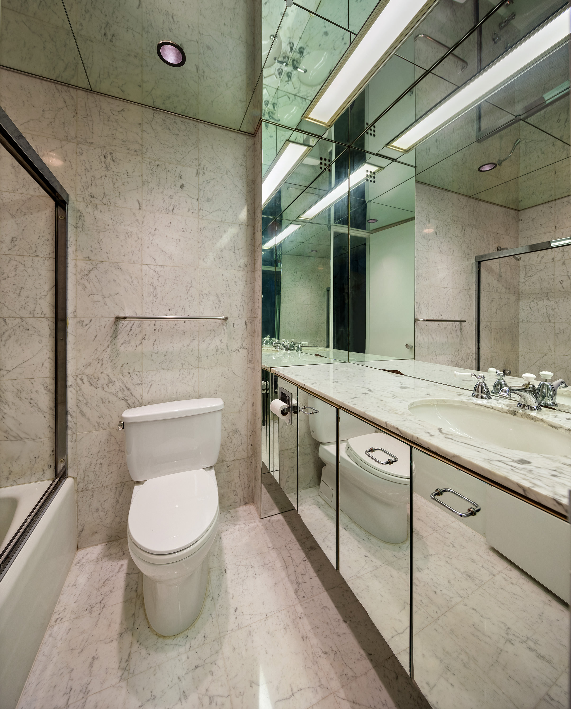 415 East 54th Street, Unit 2A Manhattan, NY 10022 - Photo 12 of 16 a bathroom with a granite countertop toilet sink and mirror