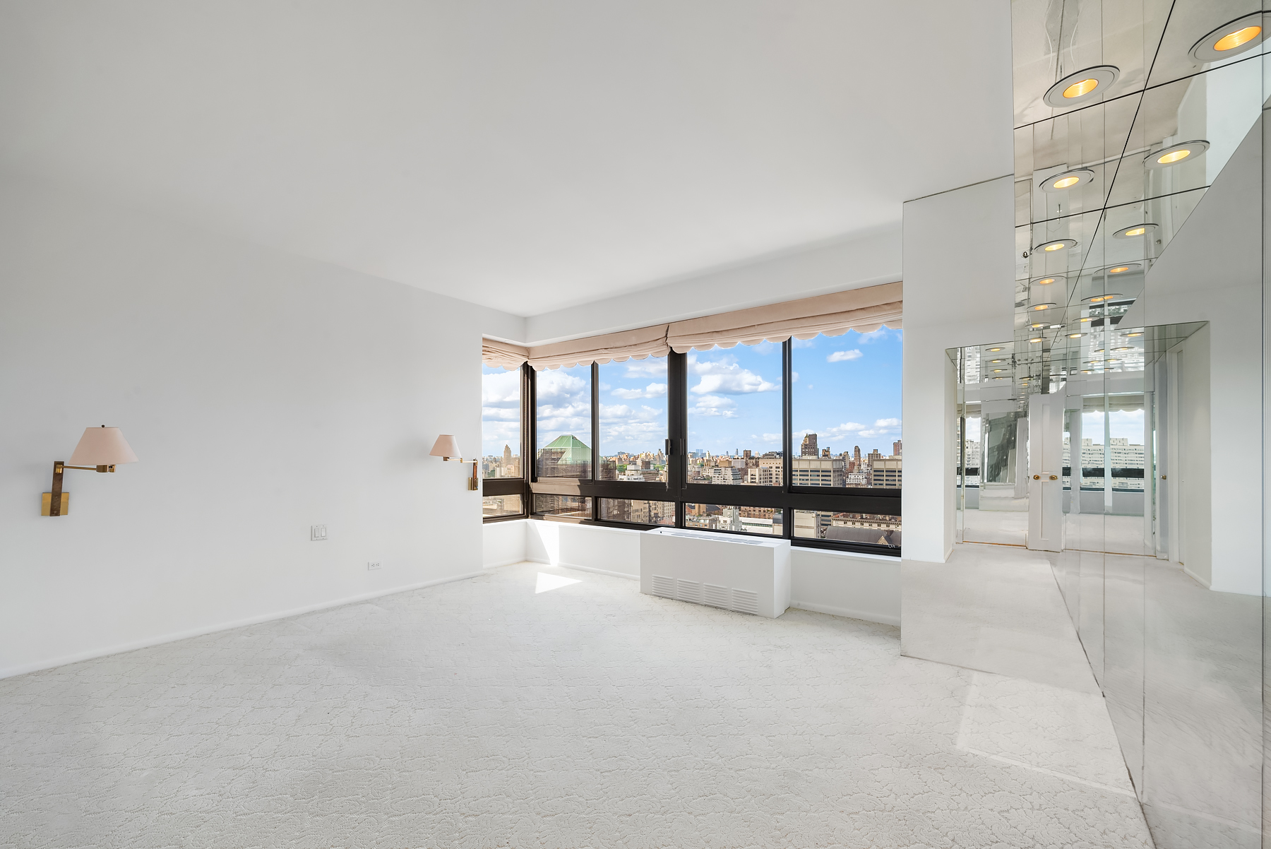 167 East 61st Street, Unit 29C Manhattan, NY 10065 - Photo 6 of 17 a large white room with windows and chandelier
