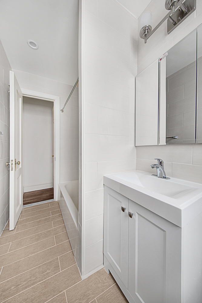 408 8th Avenue, Unit 2A Brooklyn, NY 11215 - Photo 5 of 7 a bathroom with a sink a toilet and mirror