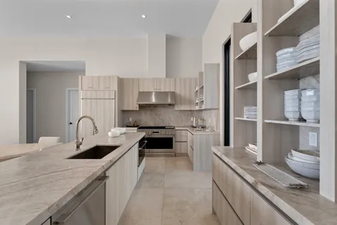 a kitchen with white cabinets and appliances