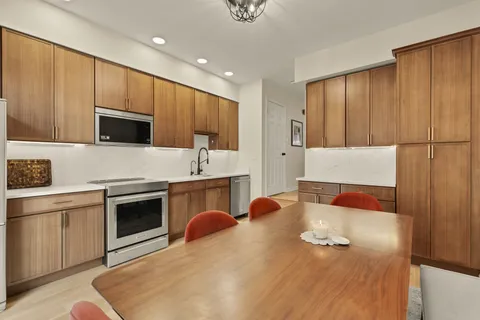 a kitchen with stainless steel appliances granite countertop a stove a sink and a microwave