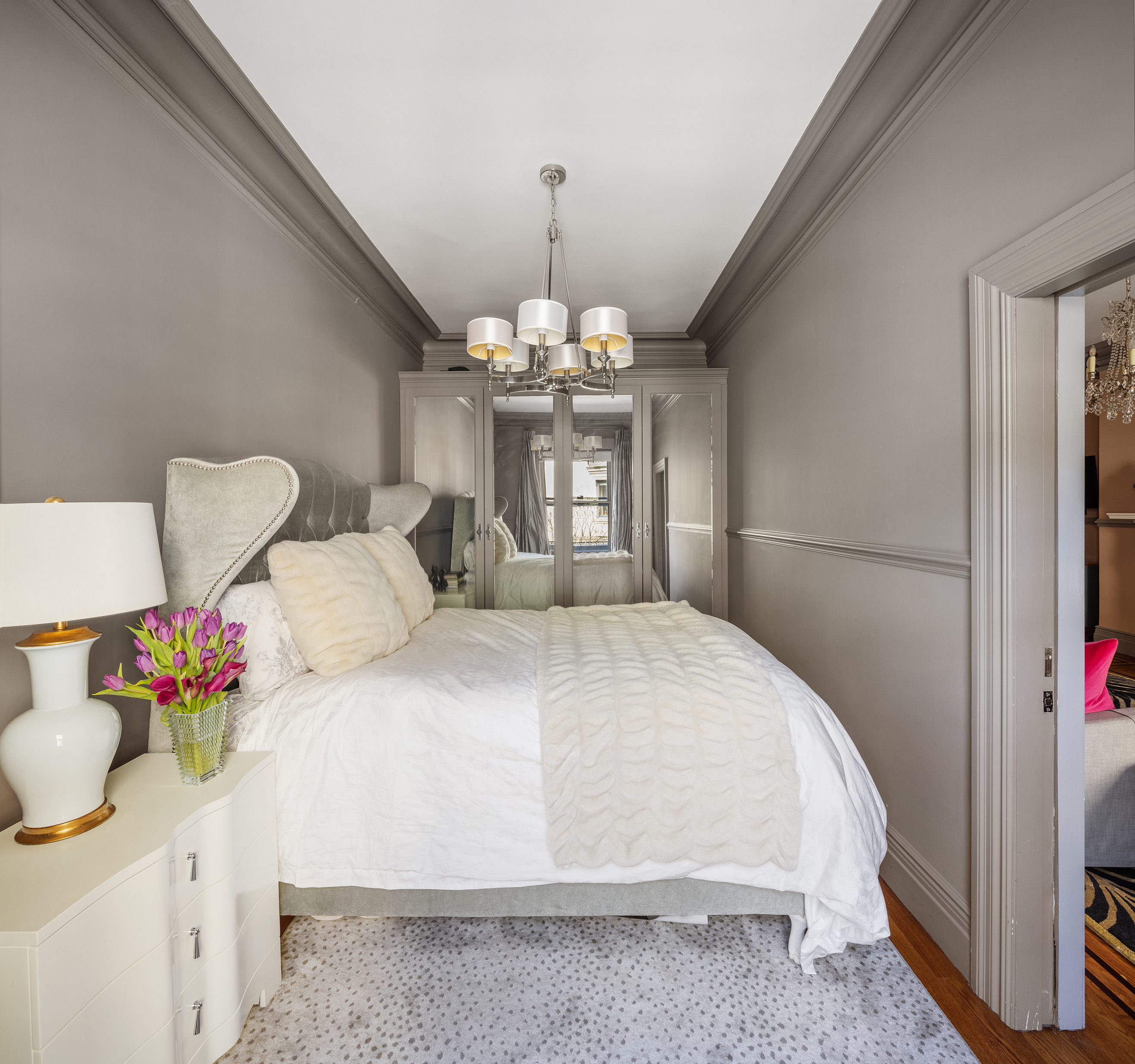 6 East 76th Street, Unit 3F Manhattan, NY 10021 - Photo 7 of 11 a bedroom with a bed and a chandelier