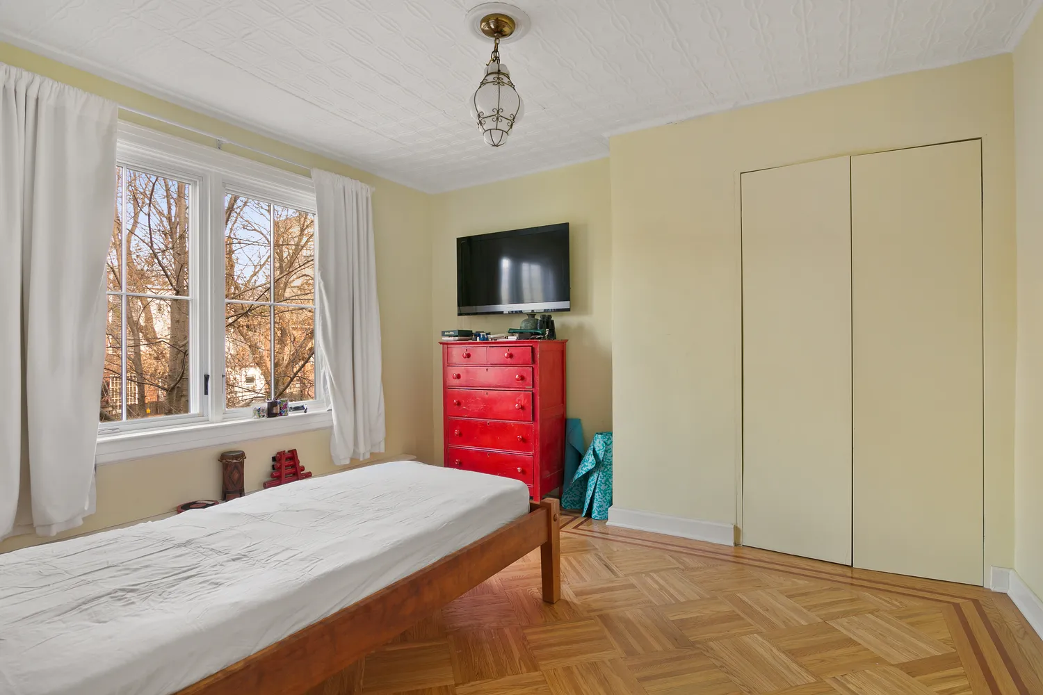 a bedroom with a bed dresser and a window