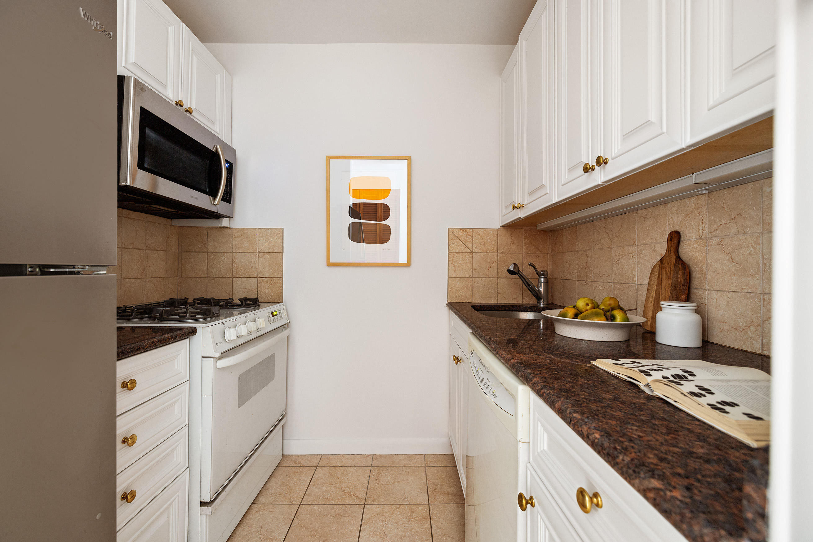 30 West 61st Street, Unit 12G Manhattan, NY 10023 - Photo 4 of 7 a kitchen with granite countertop a stove and a sink